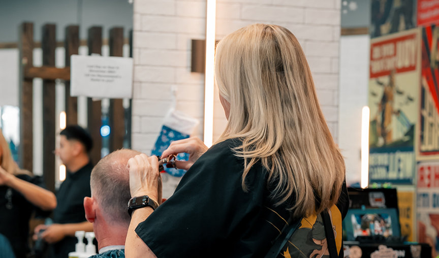 female barber giving a man a haircut